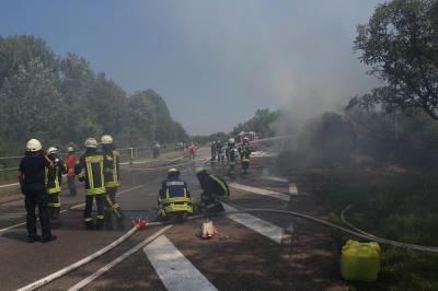 Traktoranhaenger mit Stroh brennt auf der K31 bei Germersheim